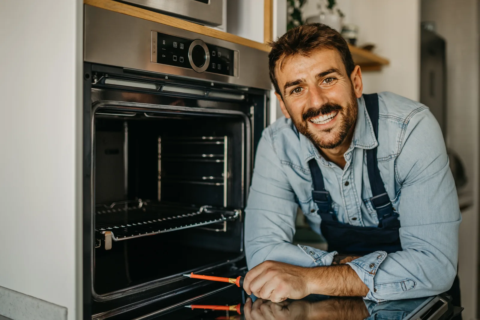 Techniker neben geoeffnetem Backofen